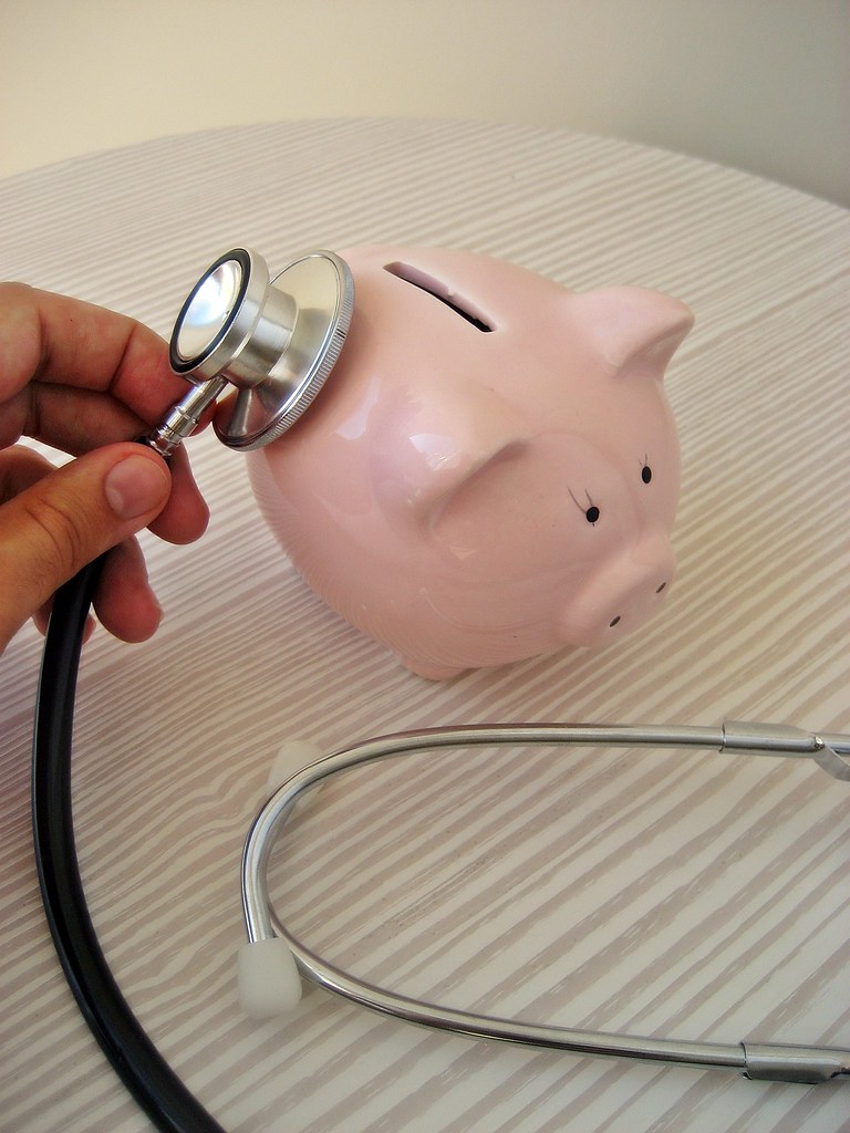 Stethoscope resting on a piggy bank, representing the cost of health insurance during ACA open enrollment