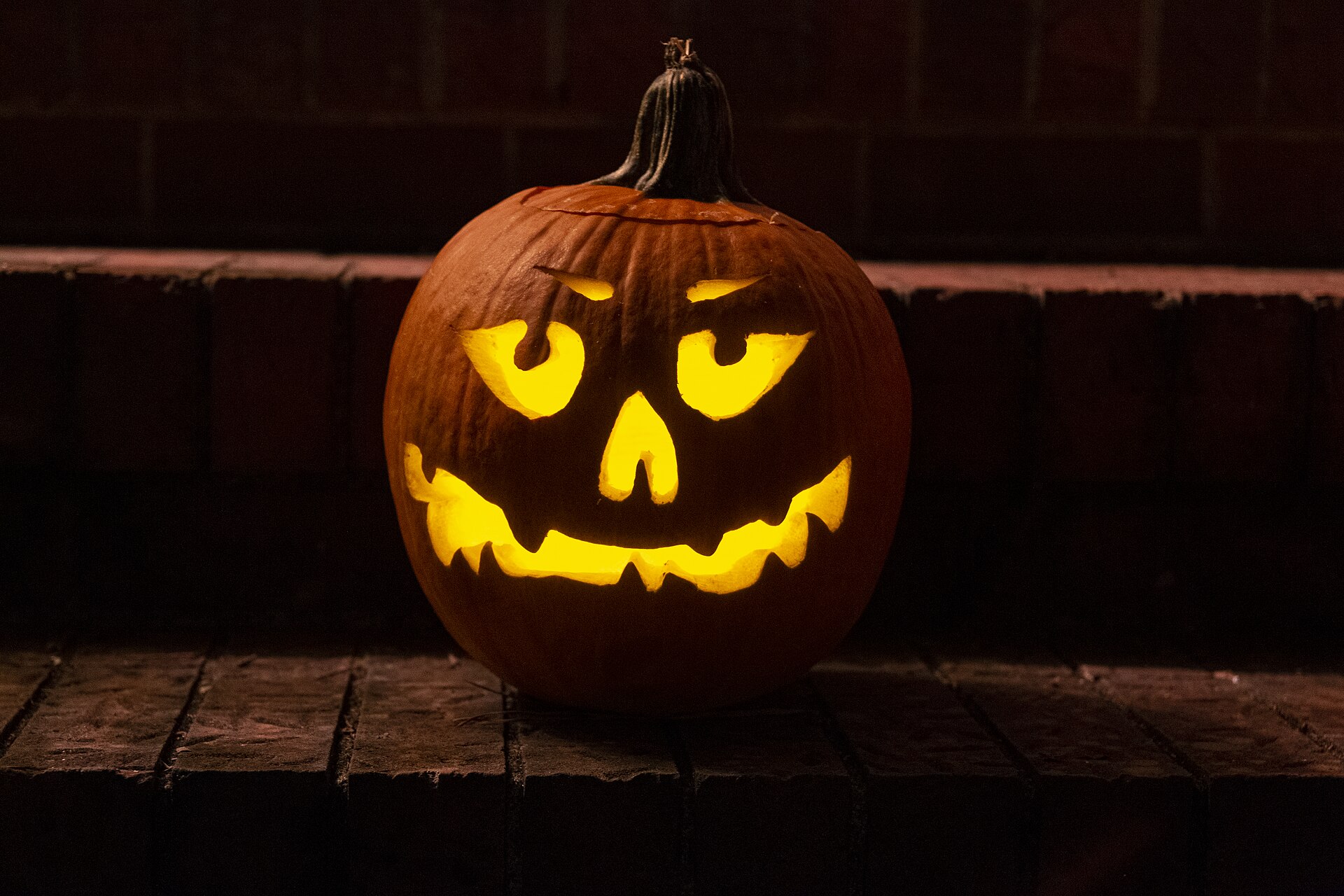 Carved jack-o-lantern glowing at night on Halloween